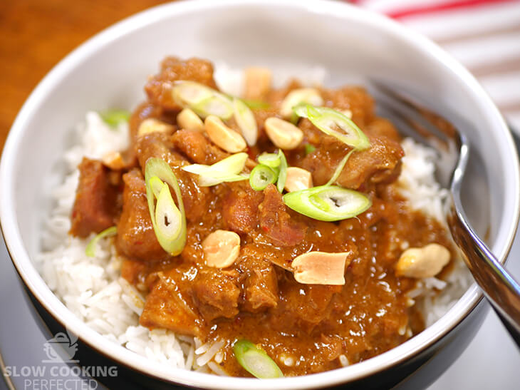 Slow-cooked Thai peanut chicken curry with rice and scallions